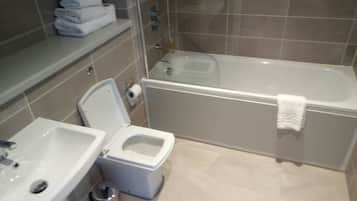 A bathroom with a toilet, sink, and bathtub.