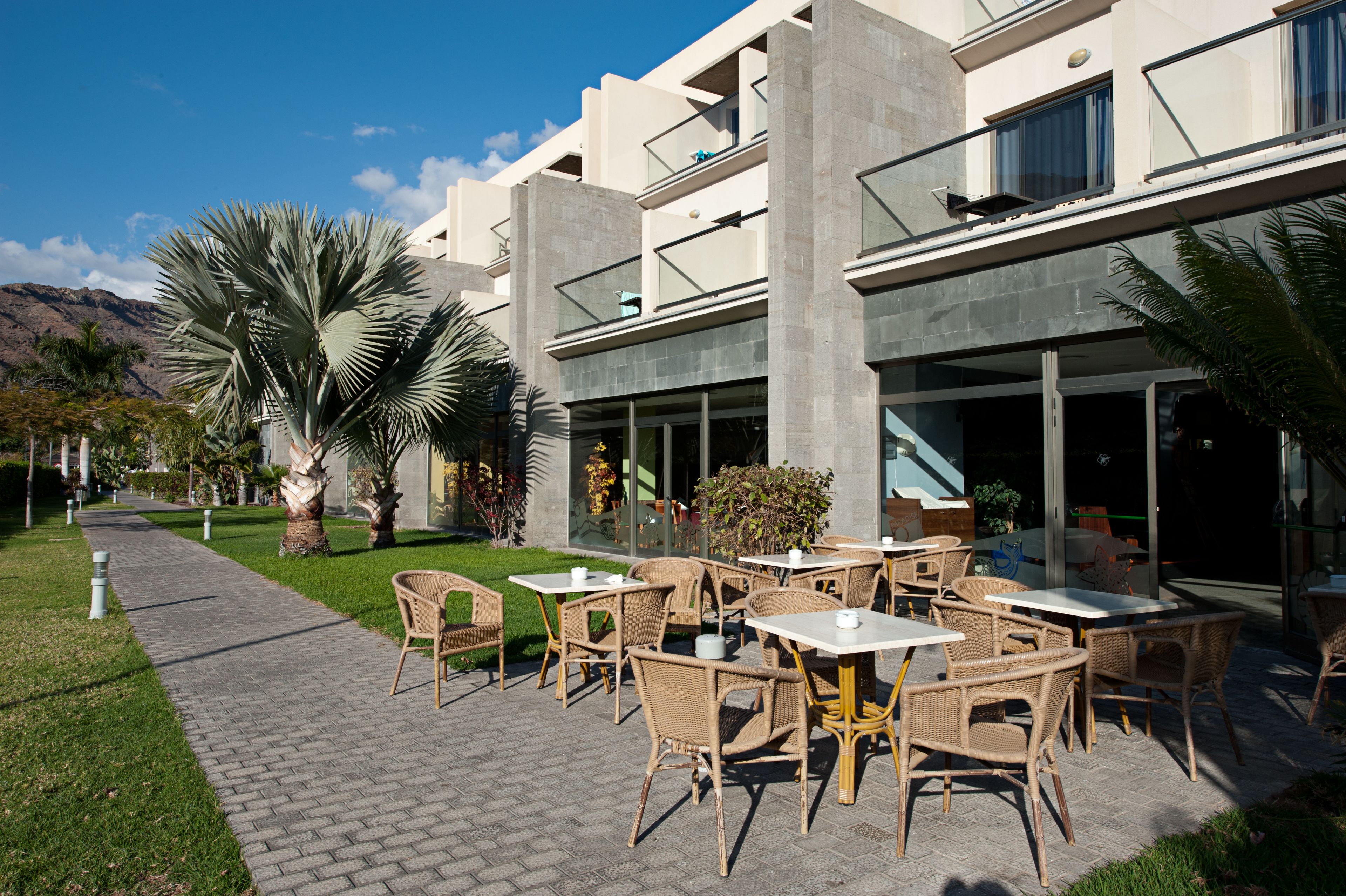 Un patio al aire libre con mobiliario de mimbre y un camino pavimentado.