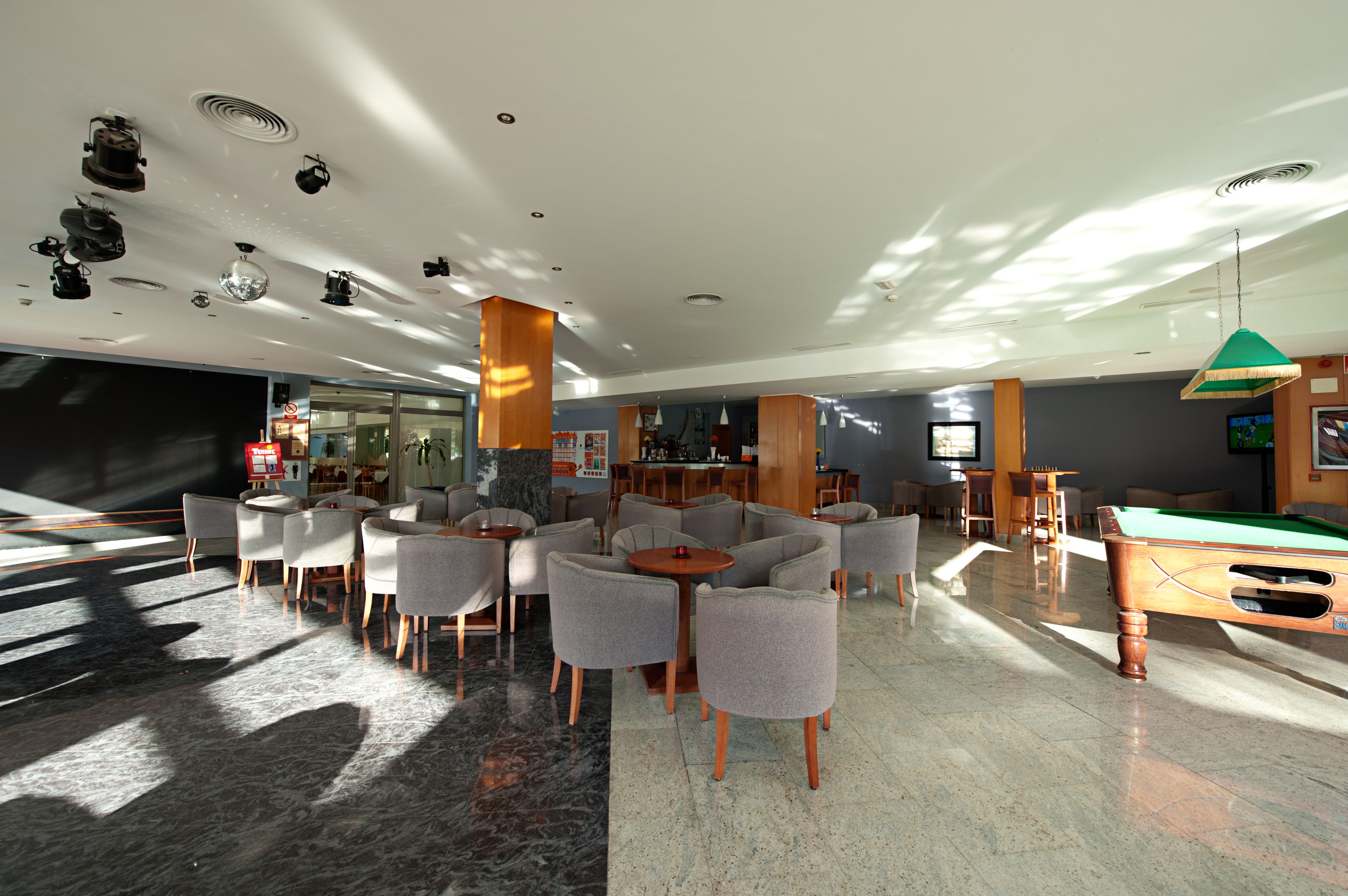 Un hall d’entrée spacieux avec une table de billard, plusieurs coins salon et un bar.