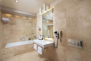 Un baño moderno con bañera, lavabo, espejo y ducha.