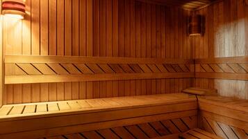 Una sauna de madera con bancos y un aplique en la pared.