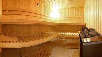 A sauna with wooden benches and a stone-filled container.