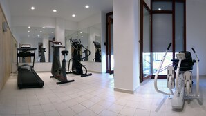 A modern gym with various exercise equipment, including treadmills and elliptical machines. - Hotel Savoy (Timisoara)