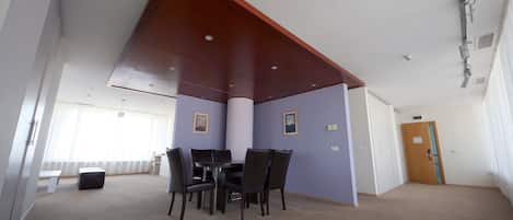 Una habitación con una mesa de comedor, sillas, un banco y una puerta.