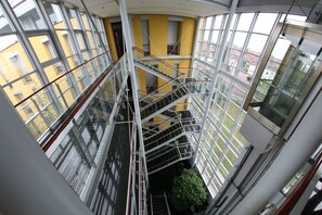 A multi-level interior with glass railings and a central staircase. - Hotel Savoy (Timisoara)