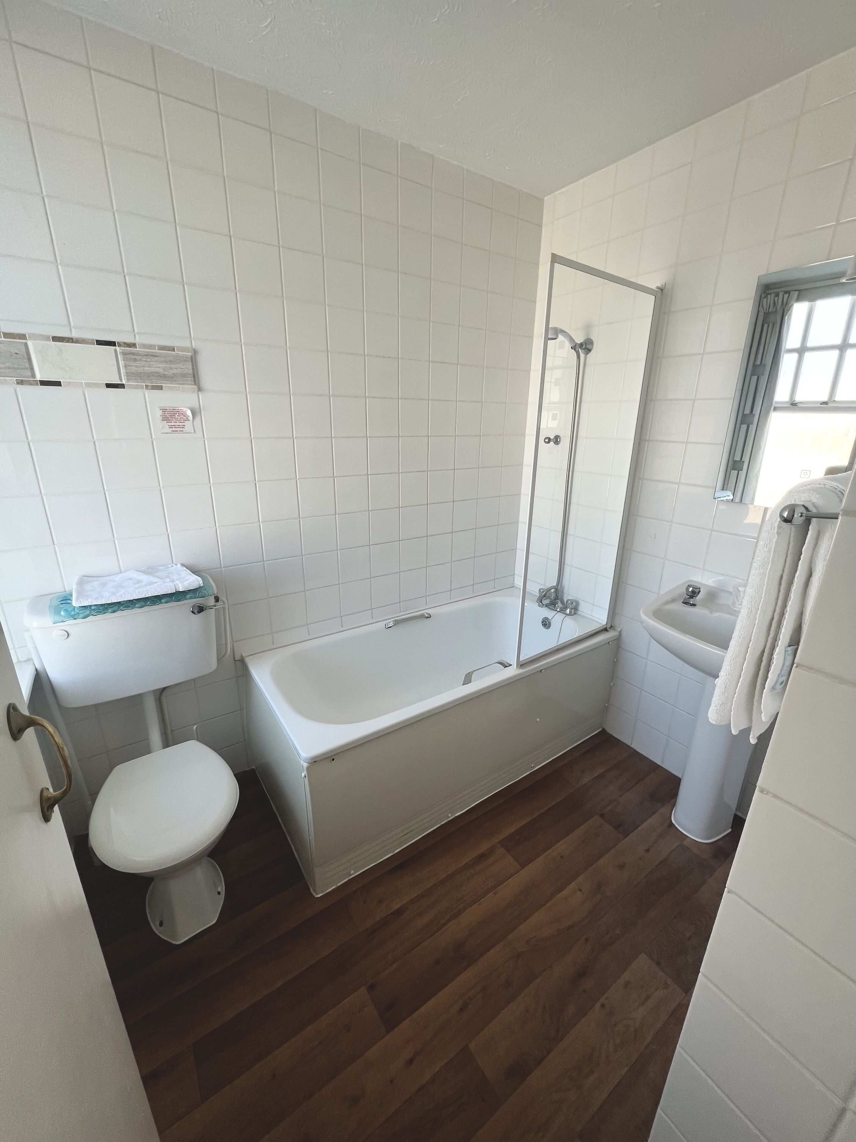 A bathroom with a toilet, sink, and bathtub.