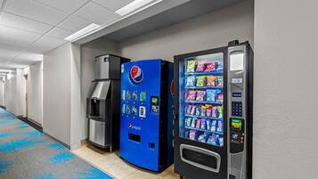 A hallway with vending machines, including a Pepsi cooler and a snack vending machine.