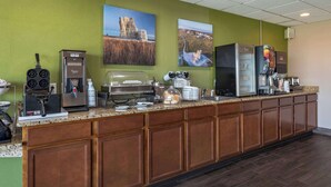 Zona de buffet per esmorzar amb màquines de cafè, ferruixador de gofres i nevera.