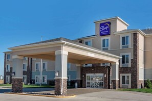 A hotel with a covered entrance, multiple floors, and a prominent sign for 'Sleep Inn & Suites by Choice Suites'. - Sleep Inn & Suites Oakley I-70 (Oakley)