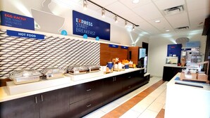 A breakfast area with labeled sections for hot food, cereal, and fruit.