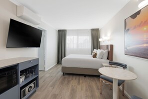 A hotel room with a bed, a TV, a desk, and a chair. - Club Wyndham Mission Beach (Mission Beach)