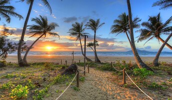 En la playa, arena blanca, sillas reclinables de playa, sombrillas