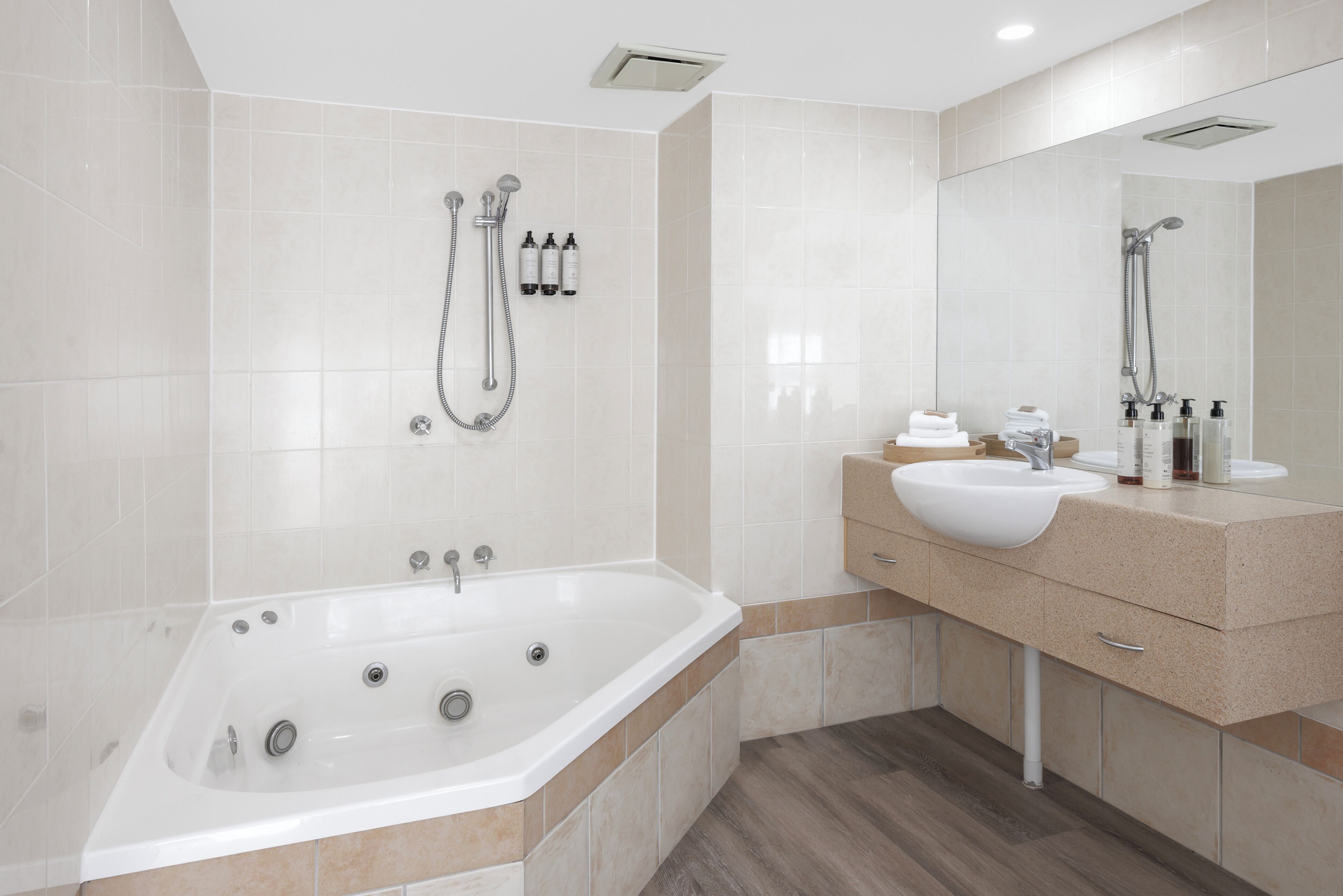 A modern bathroom with a freestanding bathtub, a vanity with a sink, and a large mirror.