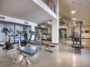 A spacious gym with treadmills, elliptical machines, and weightlifting equipment. - Parc Hotel (Castelnuovo del Garda)