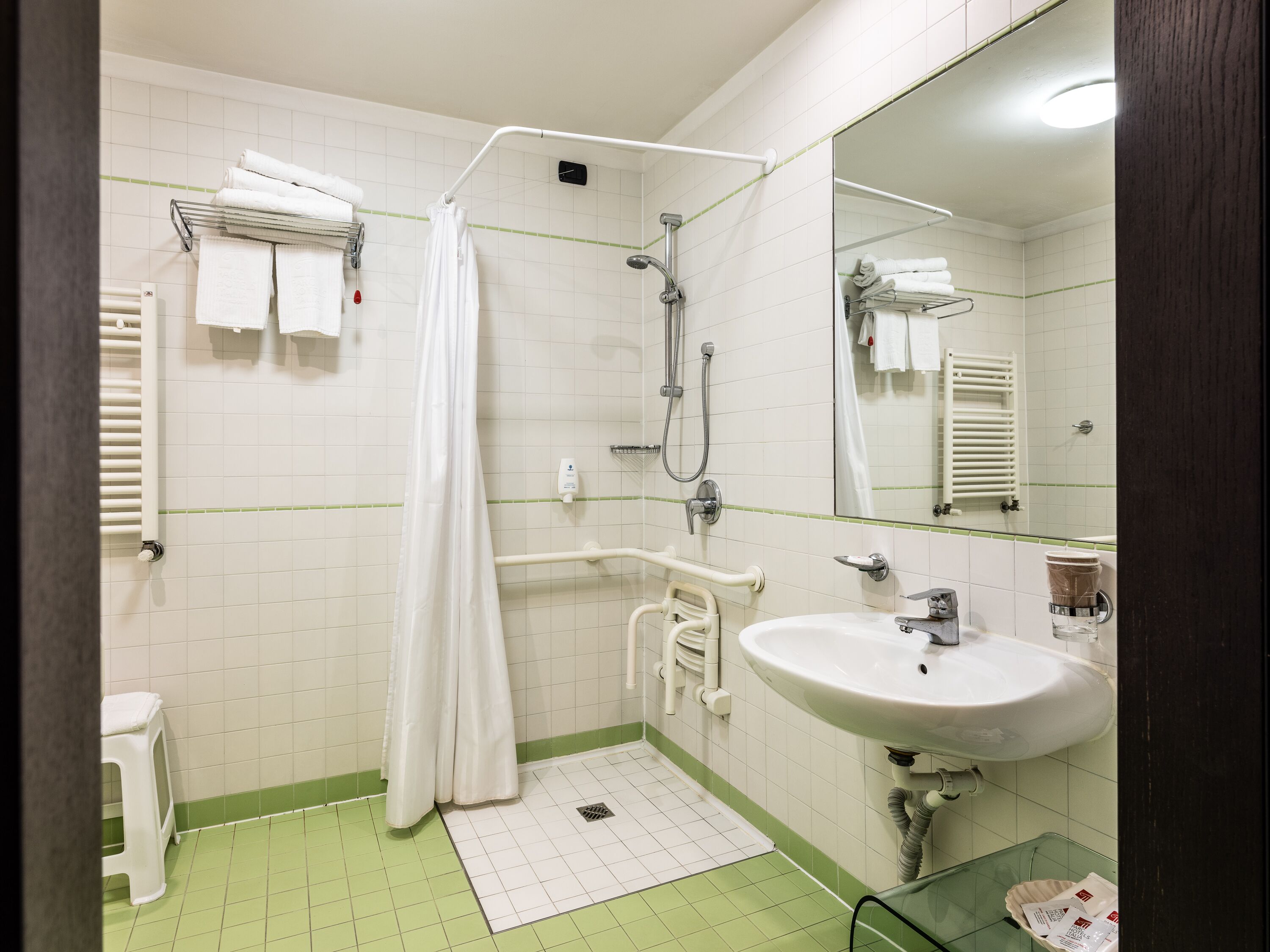 Une salle de bain équipée d’une douche, d’un lavabo, d’un miroir et de toilettes.