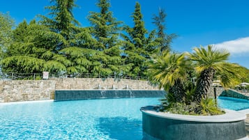 Una piscina techada, 3 piscinas al aire libre, sombrillas