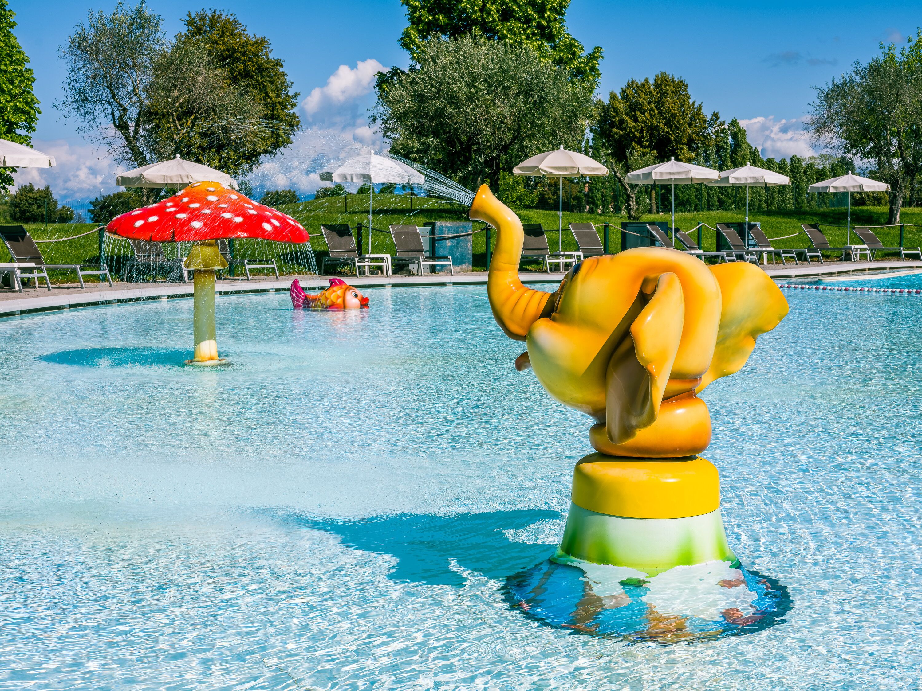 A swimming pool with a large, colorful sculpture of a fish and a mushroom.