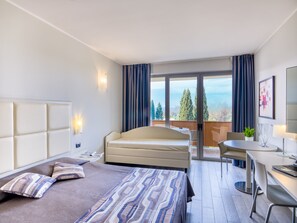 Una habitación de hotel moderna con cama, escritorio y balcón con vistas.