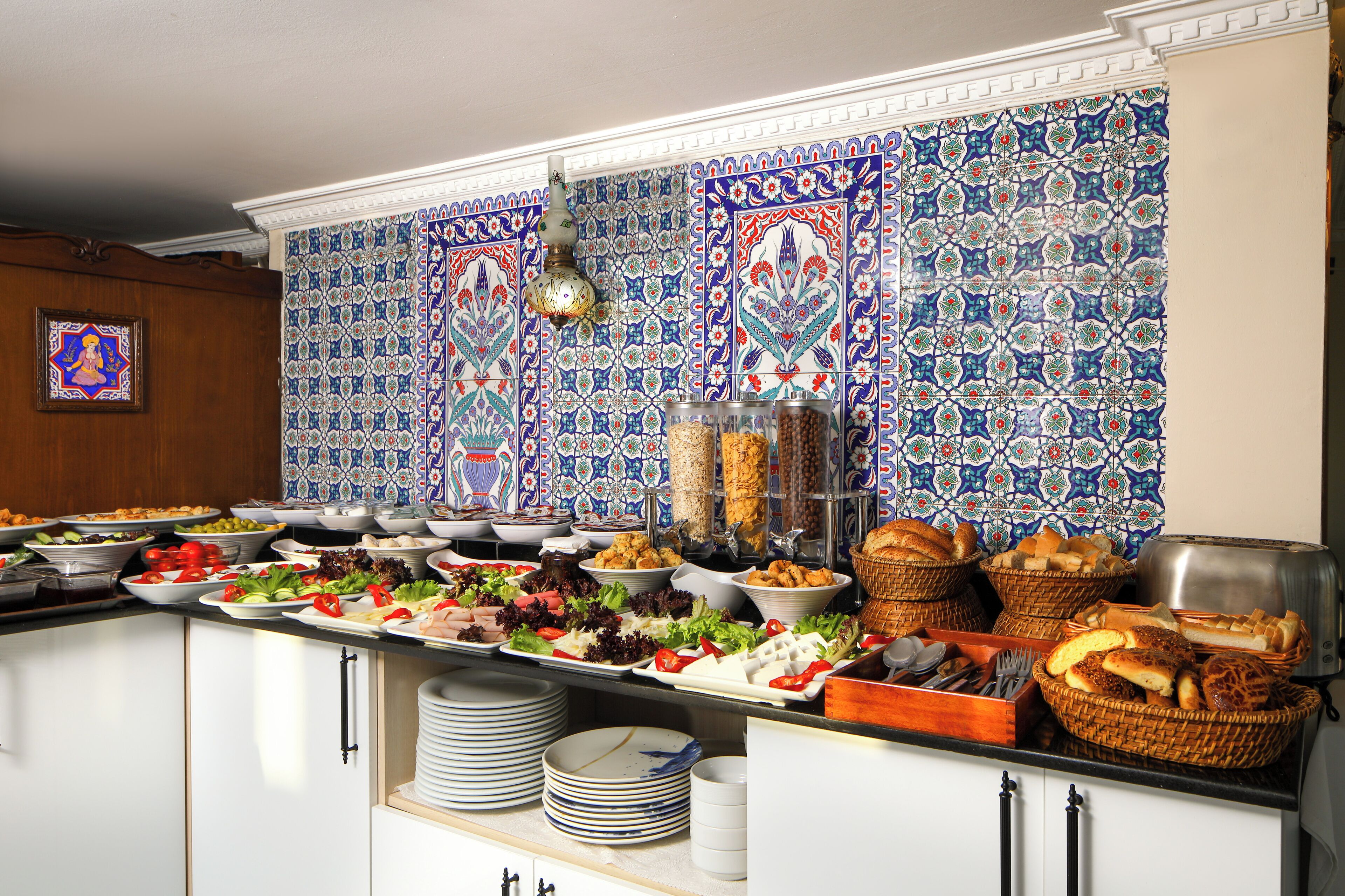Un bufé con diferentes platillos y un decorativo revestimiento de azulejos.