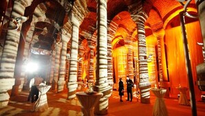 Edifici històric amb columnes i arcades grans i amb estria, que disposa de taules i cadires per a visitants.
