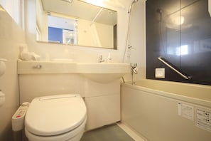 A compact bathroom with a toilet, sink, and bathtub.