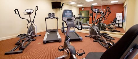 A gym with treadmills, elliptical machines, and stationary bikes.