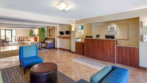 A hotel lobby with a reception desk, seating area, and a dining section. - Quality Inn Raleigh Downtown (Raleigh)