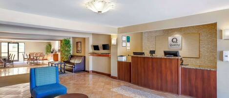 Hall dell'hotel con reception, area salotto e zona ristorazione.