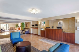Un hall de hotel con mostrador de recepción, zona de estar y área de comedor.