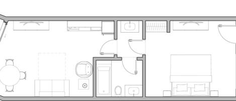 Plano de planta de una habitación de hotel que incluye una cama, un escritorio, una silla, un baño pequeño y una zona de estar.