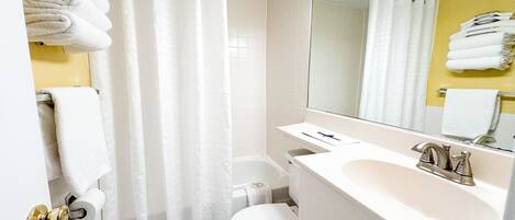 A bathroom with a toilet, sink, and shower curtain.