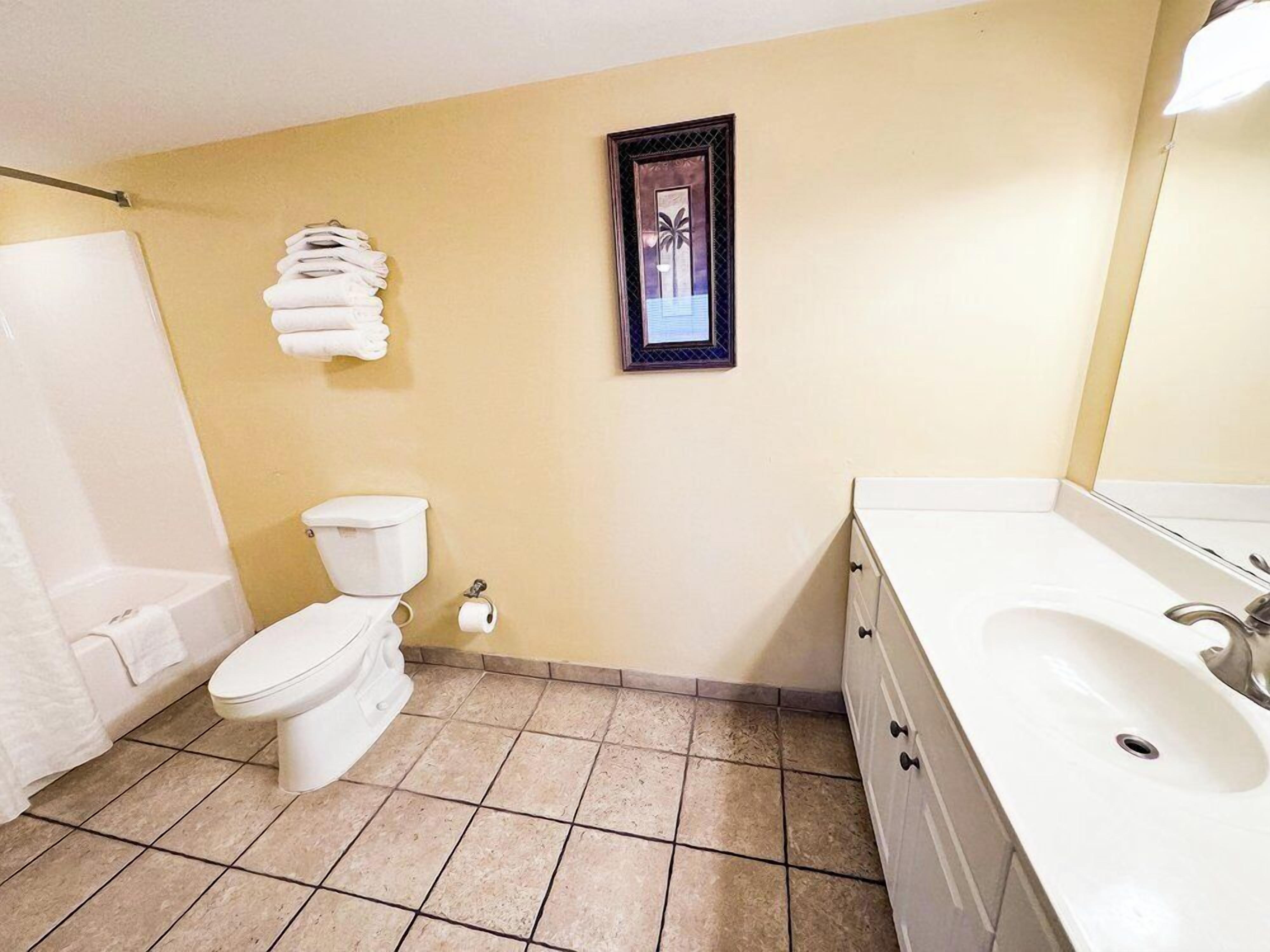 Une salle de bain avec des toilettes, un lavabo et une baignoire.