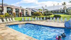 A swimming pool with lounge chairs and a view of hotel buildings.