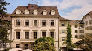 A historic building with a sign reading "Der Teufelhof Basel," featuring a classic European architectural style with symmetrical windows and a tiled roof. - Der Teufelhof Basel (Basel)