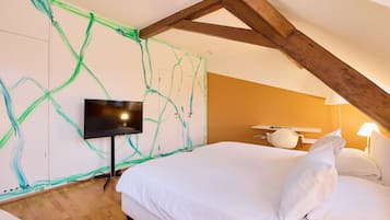 Un dormitorio con cama, televisor de pantalla plana y pared con pintura verde abstracta.