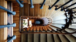 A wooden staircase with a central landing area and metal railings. - Der Teufelhof Basel (Basel)