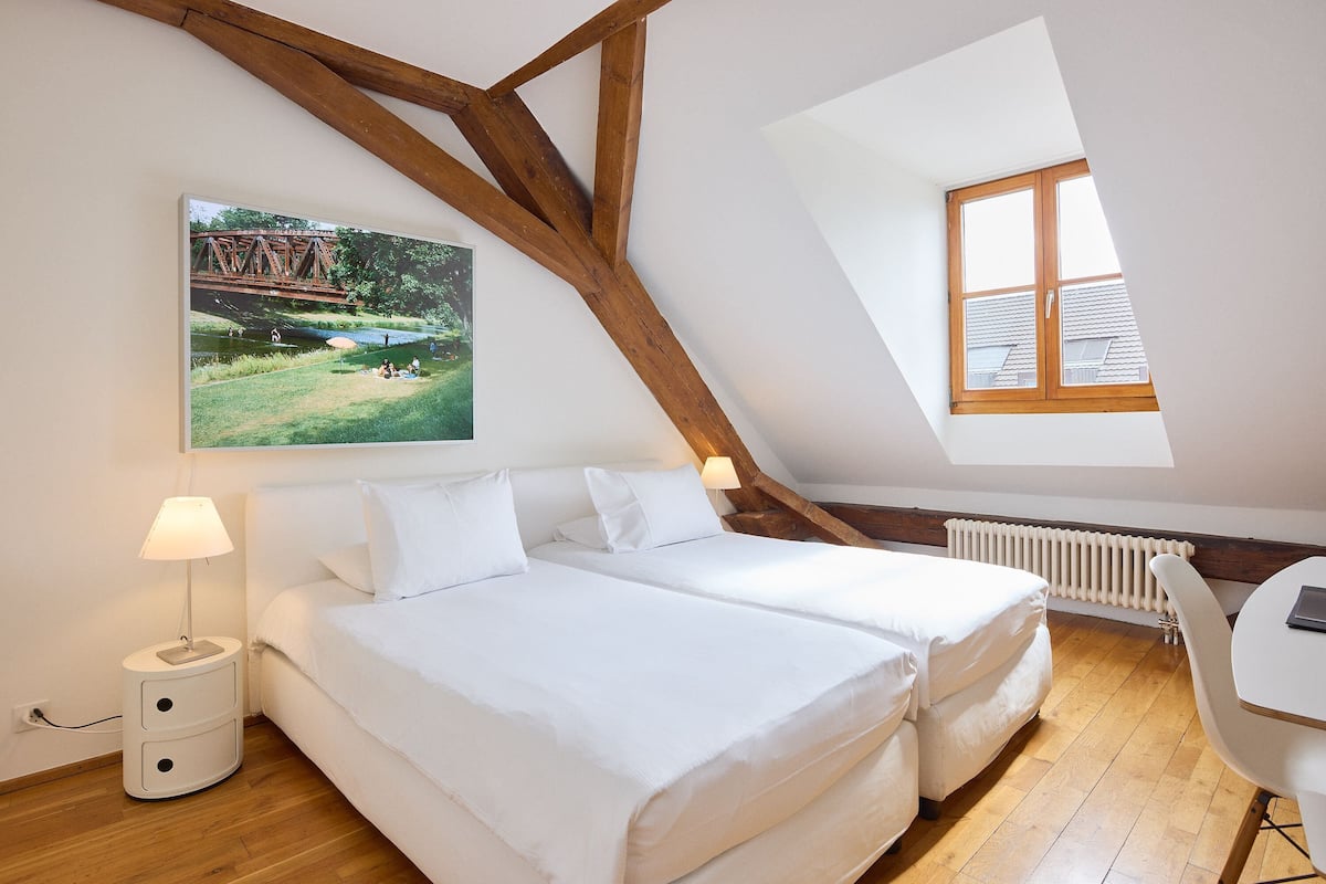 Un dormitorio con dos camas, un escritorio y una ventana.