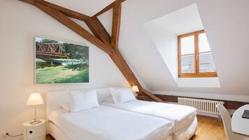 Une chambre avec deux lits, un bureau et une fenêtre.