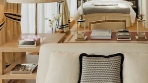 Een hotelkamer met een bed, twee nachtkastjes, een lamp en uitzicht op groen buiten.