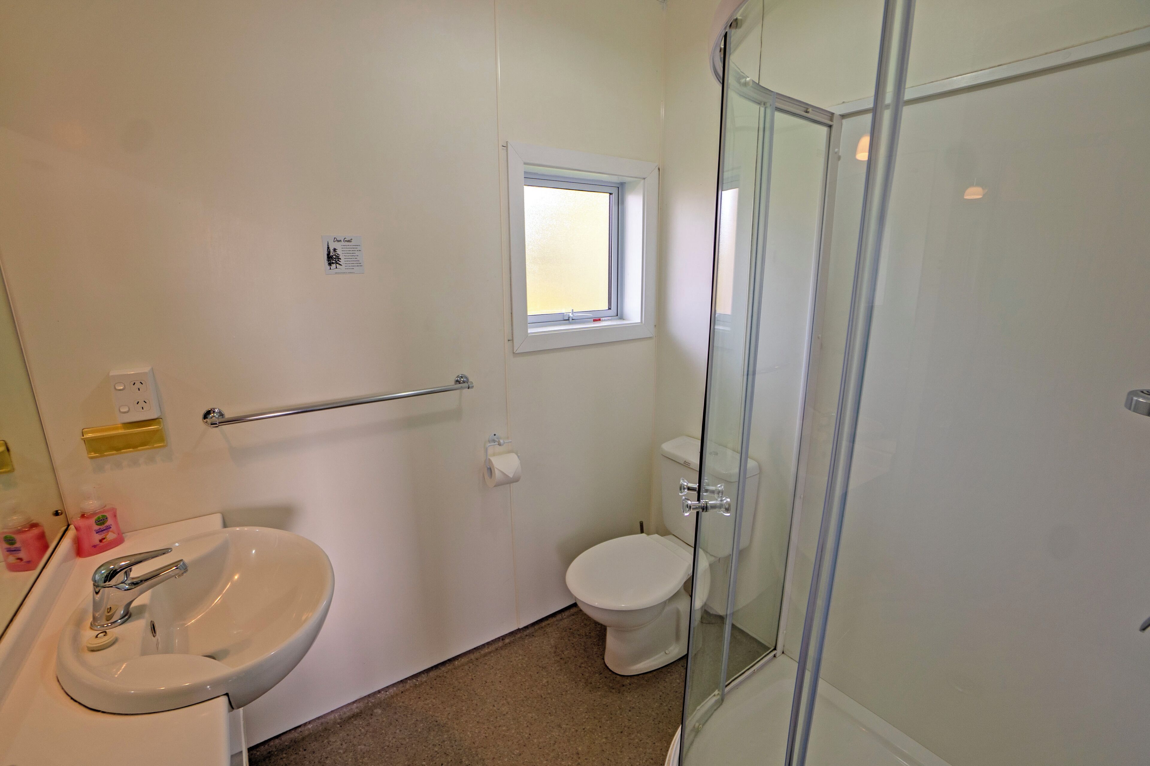 A bathroom with a sink, toilet, and glass shower enclosure.