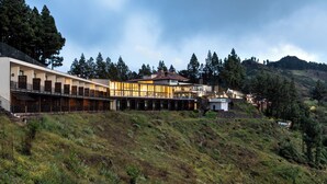 Un hotel moderno con una estructura alta y alargada, grandes ventanales y techo plano.