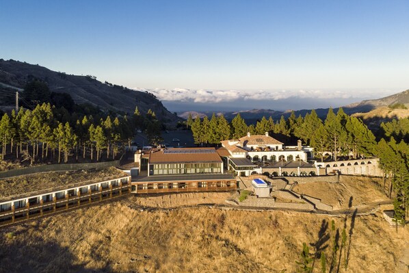 A modern building with a long, narrow structure and a large, open courtyard. - Parador de Cruz de Tejeda (Vega de San Mateo)