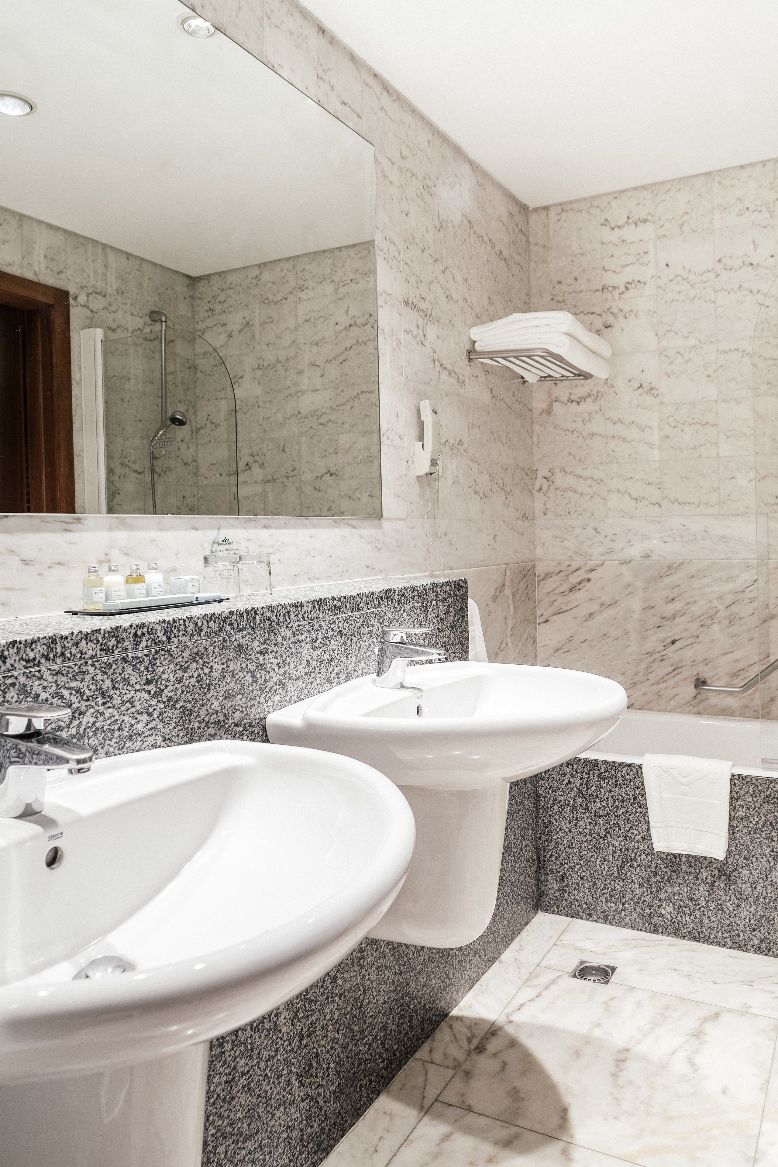 A modern bathroom with two sinks, a shower, and a bathtub.