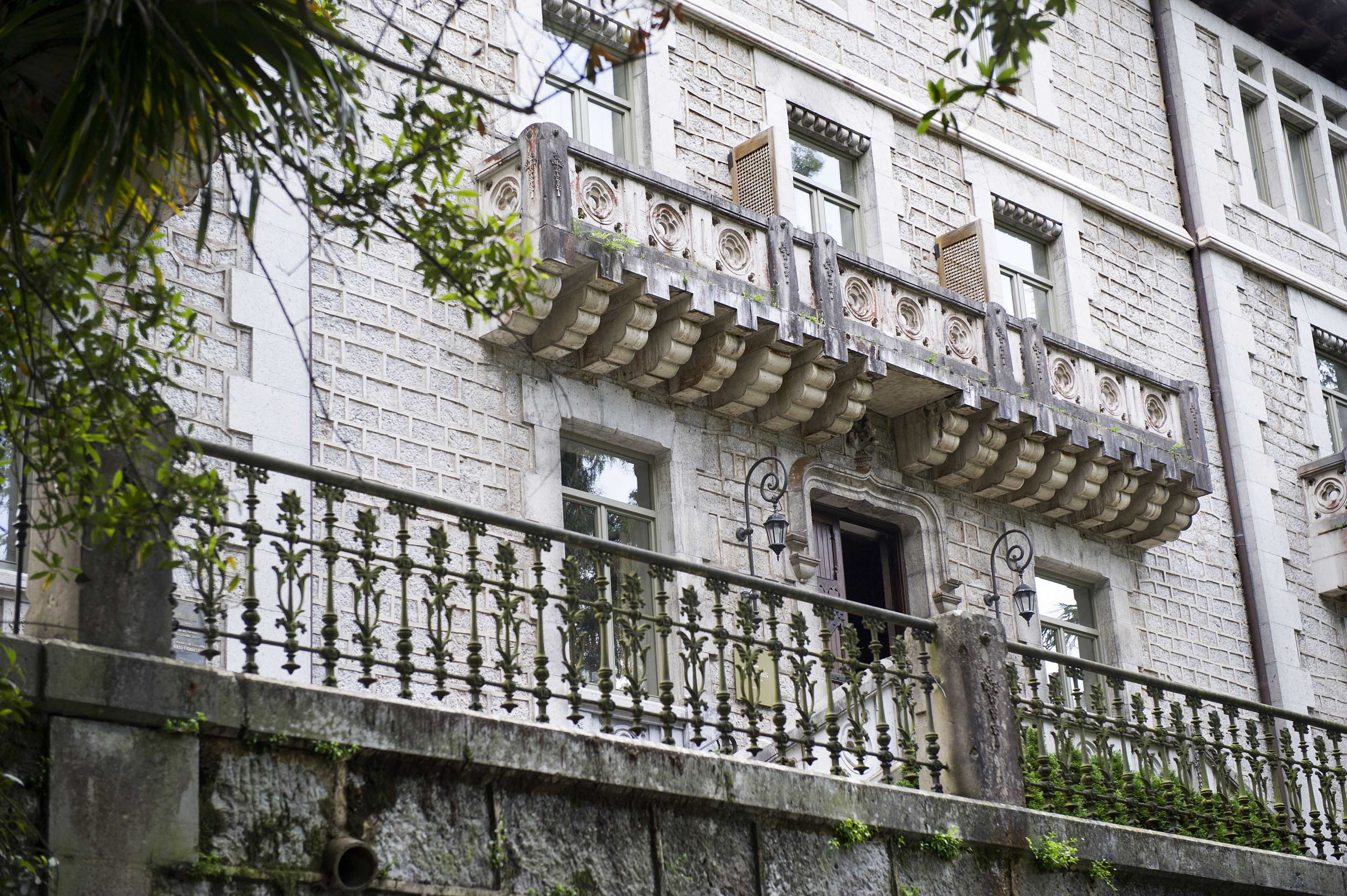 A historic building with ornate balconies and a stone facade.