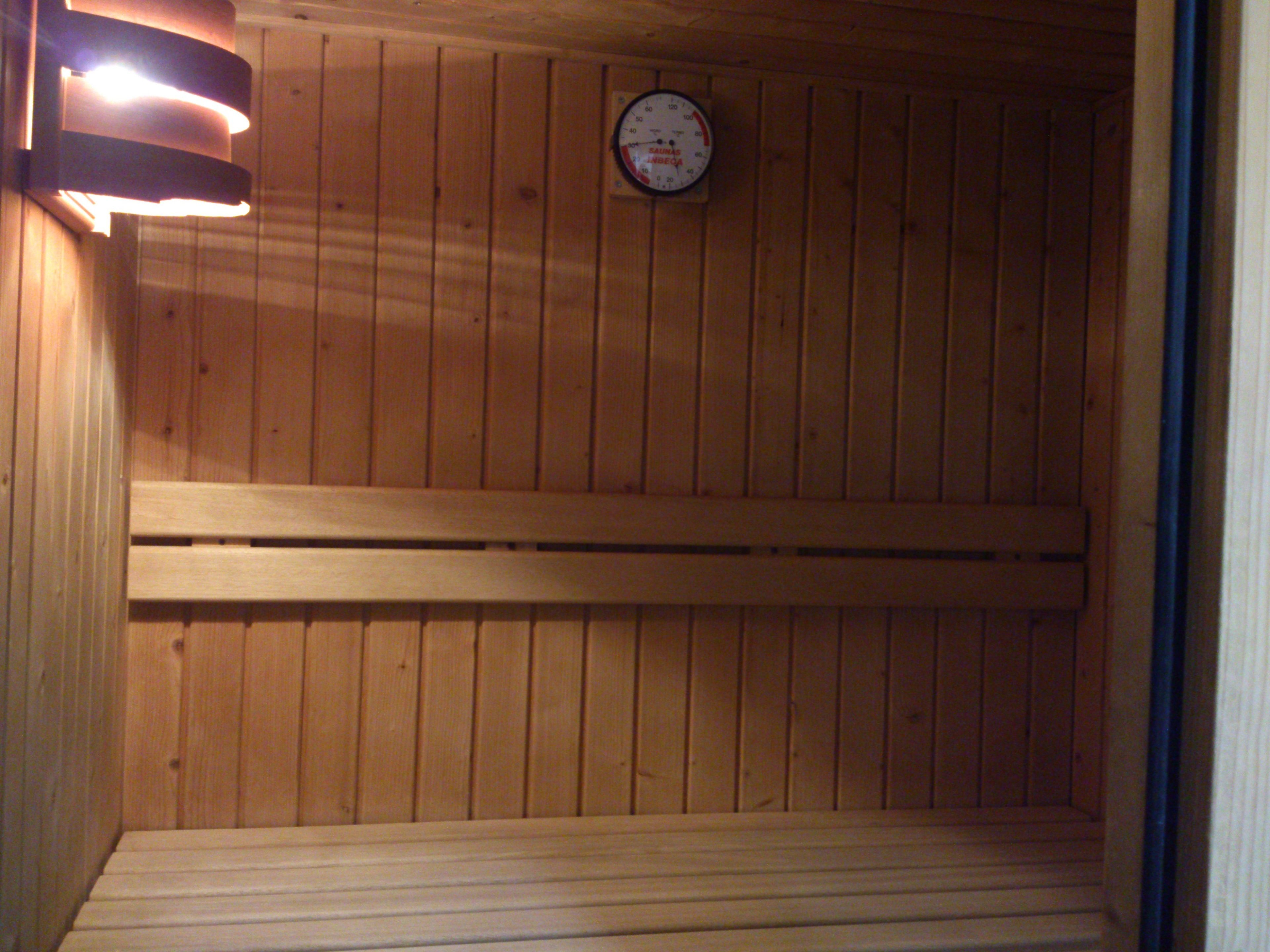 Uma sauna com paredes de madeira e um banco.