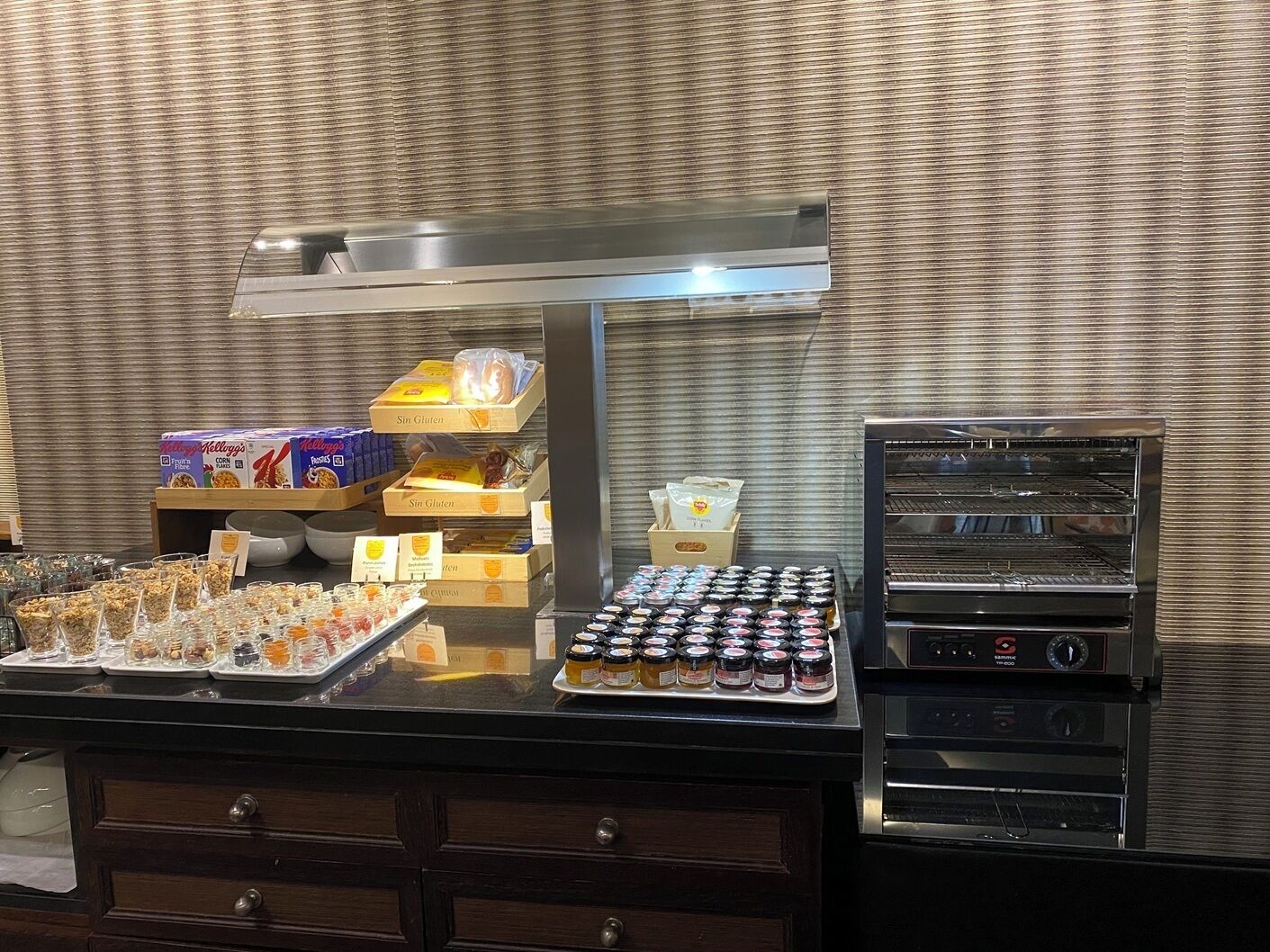 Un espace buffet proposant une variété d’aliments, notamment des céréales, des fruits et des condiments.