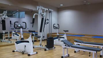 A gym with various exercise equipment, including treadmills, ellipticals, and weight machines.