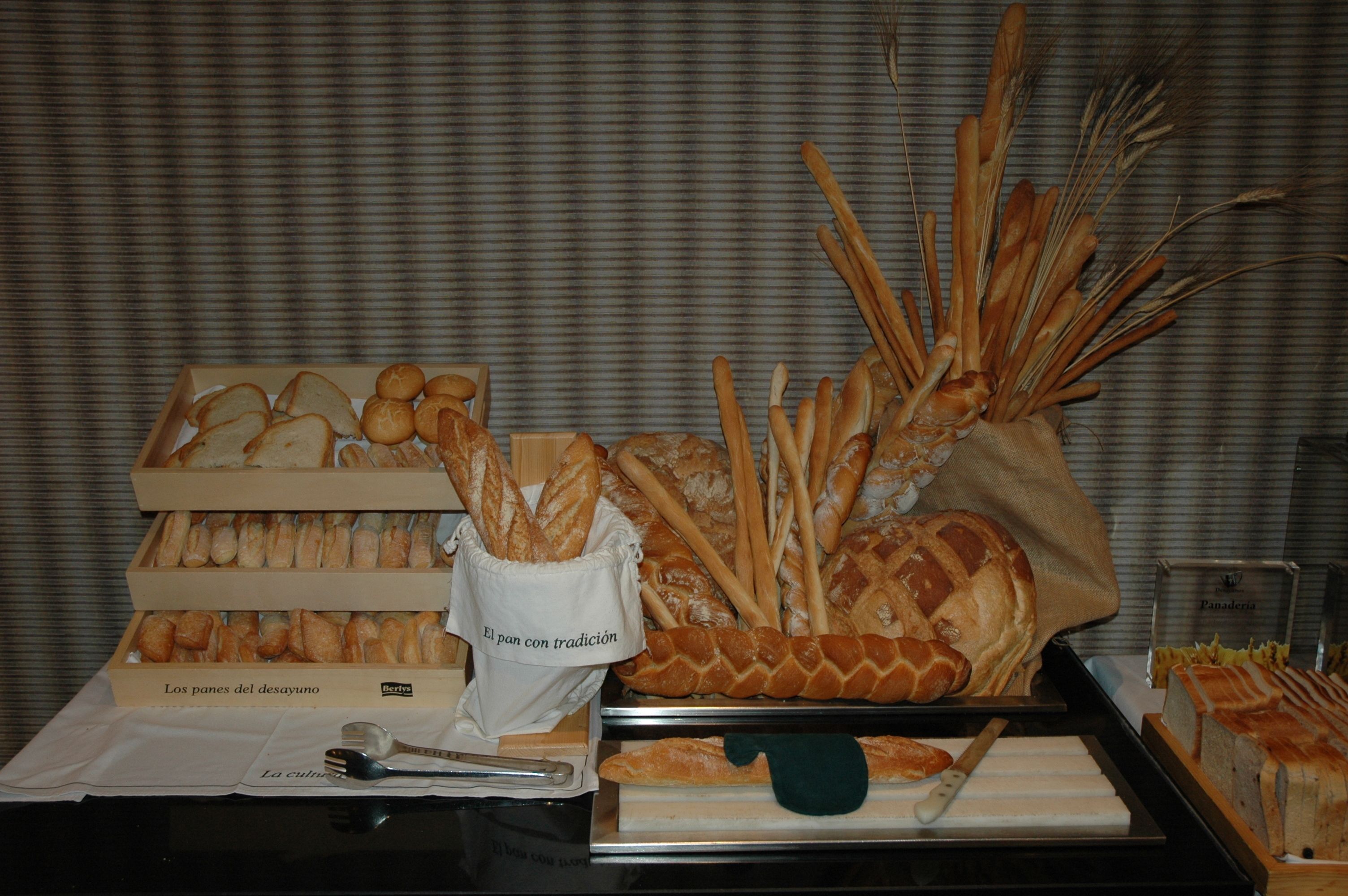 A display of various breads and pastries, including baguettes, croissants, and a loaf of bread with a braided crust.