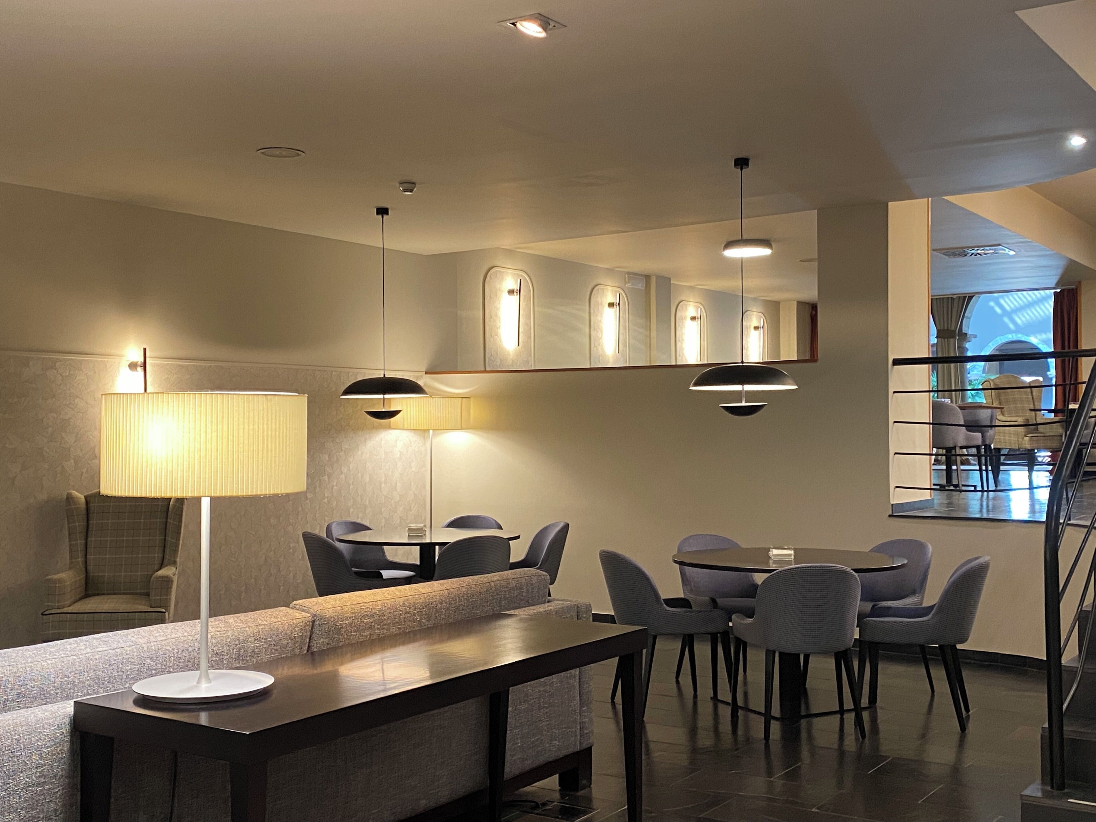 Un comedor moderno con una mesa larga, varias sillas e iluminación colgante.