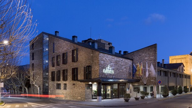 A hotel with a modern brick facade, large windows, and a sign indicating it is a hotel. - Parador de la Seu d'Urgell (La Seu d'Urgell)